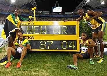 Usain Bolt stands next to the record
