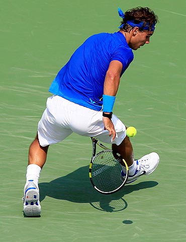 Rafael Nadal returns a shot between his legs