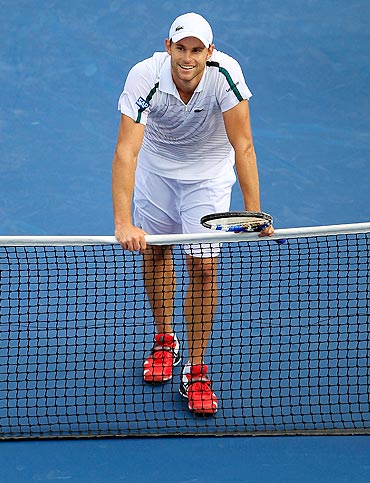 Andy Roddick celebrates at the net after defeating Julien Benneteau