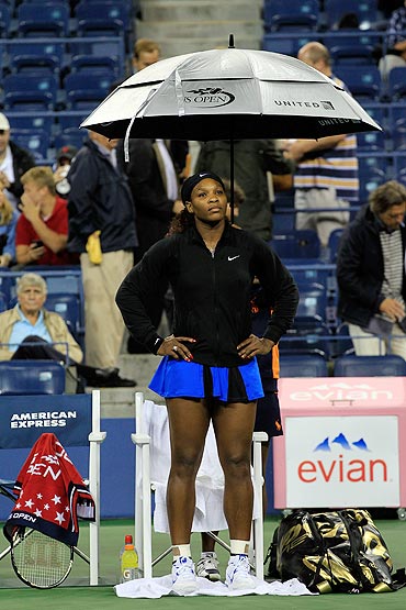 Serena Williams sits under an umbrella during a rain delay prior to her scheduled match against Anastasia Pavlyuchenkova
