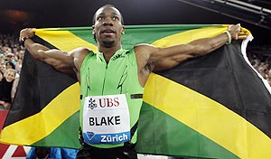 Yohan Blake of Jamaica poses with his country's national flag after winning the men's 100 metres event at the IAAF Diamond League athletics meeting in Zurich on Thursday