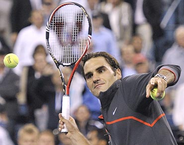 Roger Federer hits autographed balls to fans at the US Open
