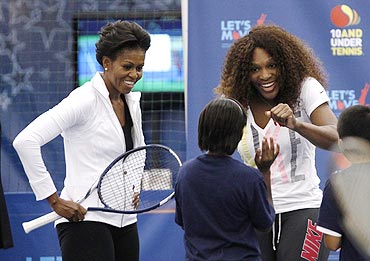 US first lady Michelle Obama and Serena Williams (right) chat with a child as Mrs Obama takes part in a 'Let's Move' tennis clinic at the US Open to promote physical activity for kids, in New York on Friday