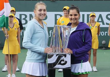 Elena Vesnina (L) and Sania Mirza pose with the trophy after winning the title at Indian Wells in March this year