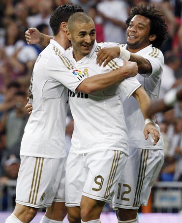 Real Madrid's Karim Benzema (centre) celebrates with teammates Marcelo and Xabi Alonso (left) after scoring against Getafe