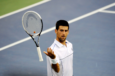 Novak Djokovic of Serbia tosses his racquet as he reacts against Rafael Nadal of Spai
