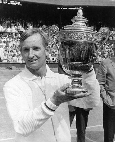Australian tennis player Rod Laver lifts the trophy after beating Tony Roche of Australia in the men's singles final at Wimbledon