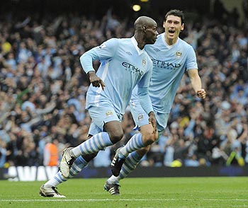 Manchester City's Mario Balotelli (left) celebrates his goal with teammate Gareth Barry during their English Premier League soccer match against Everton at the Etihad Stadium in Manchester, on Saturday