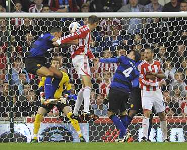 Peter Crouch scores against Manchester United at the Brittanica Stadium