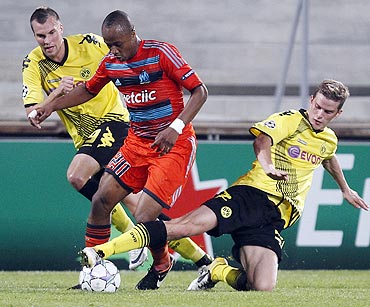 Borussia Dortmund's Kevin Grosskreutz (left) and Sven Bender (right) challenge Olympique Marseille's Andre Ayew (centre)