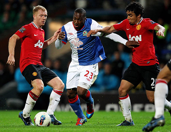 Blackburn Rovers' Junior Hoilett is challenged by Manchester United's Rafael (right) and Paul Scholes