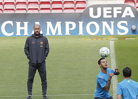 Barcelona's coach Pep Guardiola (left) watches as Tello goes through the grind during a training session at Nou Camp stadium in Barcelona on Monday
