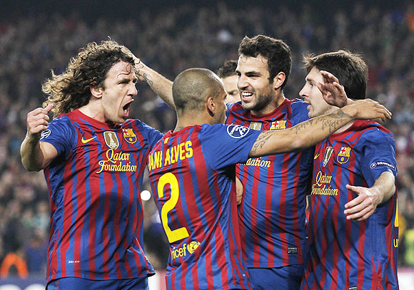 Barcelona's Lionel Messi (right) celebrates with Carles Puyol (left), Daniel Alves (second left) and Cesc Fabregas after scoring a penalty against AC Milan during their Champions League quarter-final second leg soccer match at Camp Nou stadium in Barcelona