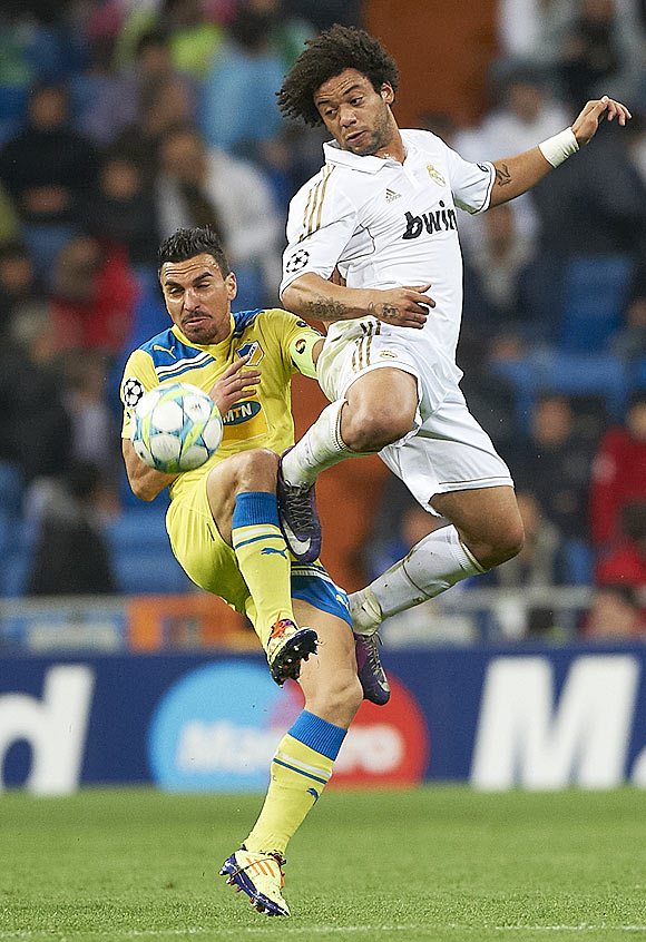 Real Madrid's Marcelo competes for an aerial ball with APOEL's Savvas Poursaitides on Wednesday