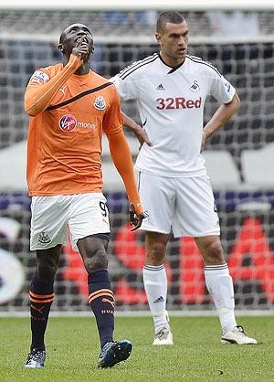 Newcastle United's Papiss Cisse (left) celebrates scoring against Swansea City as Swansea's Steven Caulker (right) wears a dejected look during their EPL match on Friday