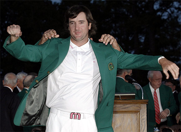 Bubba Watson of the US receives his green jacket from 2011 champion Charl Schwartzel of South Africa after winning the 2012 Masters Golf Tournament at the Augusta National Golf Club in Augusta, Georgia