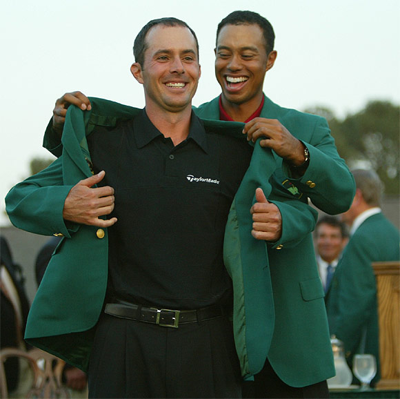 Canadian golfer Mike Weir receives his green jacket from former champion Tiger Woods after he defeated Len Mattiace in a one hole play-off  to win the 2003  Masters Championship at the Augusta National Golf Club on April 13, 2003