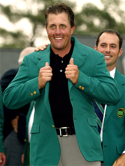 Phil Mickelson of the United States (L) is presented with the Masters green jacket by former champion Mike Weir of Canada after Mickelson won the Masters golf tournament at Augusta National Golf Club in Augusta, Georgia April 11, 2004