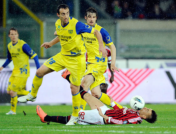 Stepahn El Shaarawy of AC Milan goes down as Dario Dainelli (left) of Chievo Verona vies for the ball during their Serie A match