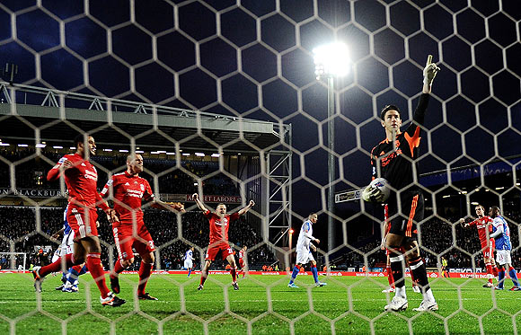 Liverpool 'keeper Brad Jones points to the sky in celebration as he saves the penalty off Yakubu during their match against Blackburn on Tuesday