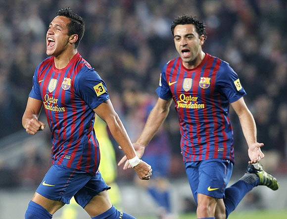 Barcelona's Alexis Sanchez (left) and Xavi Hernandez celebrate a goal against Getafe on Tuesday