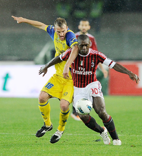 Clarence Seedorf of AC Milan (right) and Luca Rigoni Chievo Verona compete for the ball