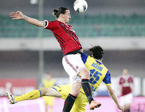 AC Milan's Zlatan Ibrahimovic (left) and Chievo Verona's Francesco Acerbi are involved in an aerial challenge