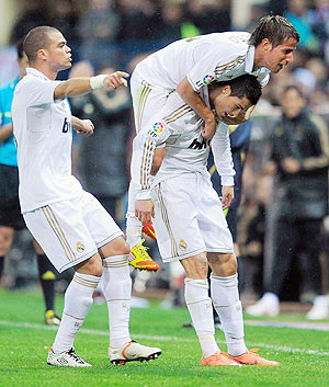 Real Madrid's Cristiano Ronaldo (right) celebrates with teammates Fabio Coentrao and Pepe after scoring against Atletico during their La Liga match on Wednesday