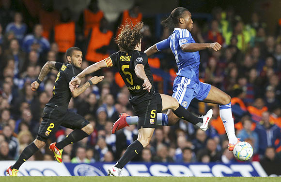 Carles Puyol (centre) of Barcelona and Didier Drogba (right) of Chelsea chase the ball during their Champions League match at Stamford Bridge