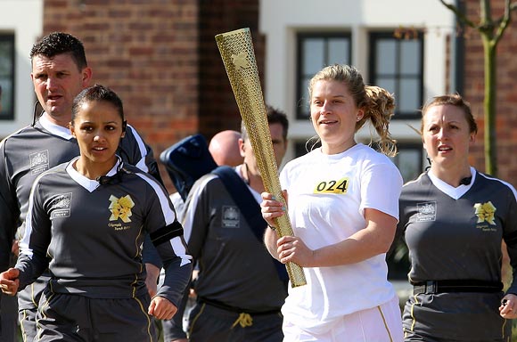A runner carries the London 2012 Olympic Torch at a torch relay dress rehersal at Loughborough University in Loughborough, England