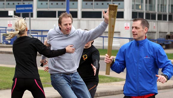 Men stage an attack during a training session for the Olympic Torch Security Team who will be protecting the torch bearers and Olympic flame during the torch relay's progress through the UK, at the Metropolitan Police Training School in London.