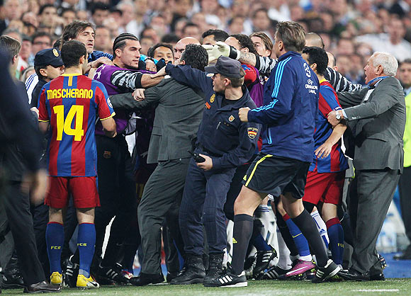 Jose Pinto of Barcelona clashes with Real Madrid official as the players leave the pitch