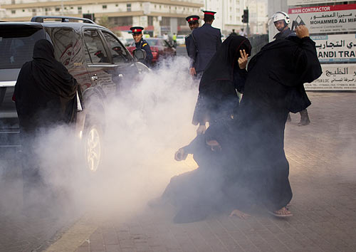 Protesters react after police used a flashbang stun grenade during an anti-government rally in Manama