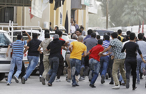 A protester shouts at riot police during an anti-government rally in Manama