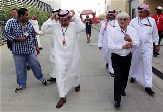 F1 supremo Bernie Ecclestone walks on the paddock with Crown Prince Sheikh Salman bin Hamad al-Khalifa and a government delegation after the second practice session of the Bahrain F1 Grand Prix at the Sakhir circuit in Manama
