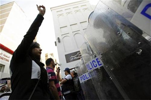 Zaynab (left), daughter of human rights activist Abdulhadi al-Khawaja, confronts riot police during an anti-government rally demanding his release, in Manama