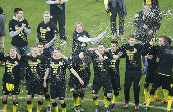Players of Borussia Dortmund are soaked in beer as they celebrate after winning the Bundesliga championship following their win over Borussia Moenchengladbach in Dortmund on Saturday