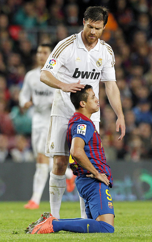 Real Madrid's Xabi Alonso comforts Barcelona's Alexis Sanchez after their El Clasico on Saturday