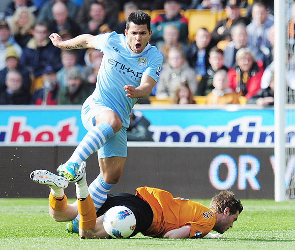 Sergio Aguero of Manchester City avoids a tackle from Richard Stearman of Wolverhampton Wanderers