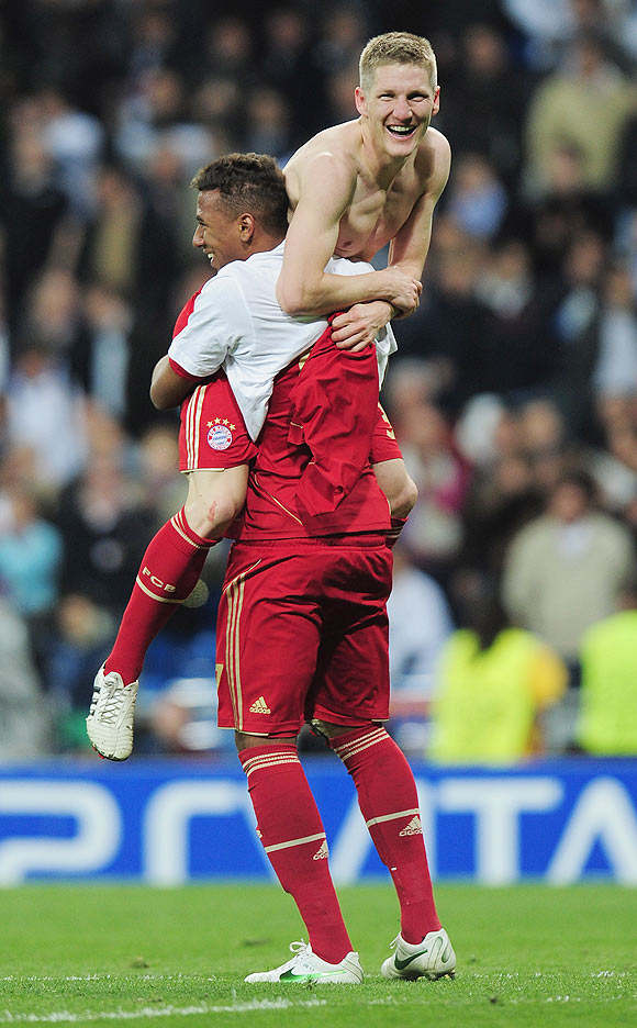Bastian Schweinsteiger of Bayern Munich celebrates with teammate Jerome Boateng after scoring the winning penalty