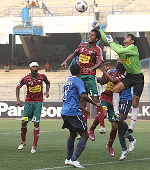 Mohun Bagan goalkeeper Shilton Pal (in green) fists a Dempo attack at the Salt Lake Stadium on Sunday
