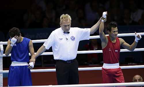 India's Devendro Singh, right, reacts after defeating Honduras' Bayron Molina Figueroa during a light flyweight 49-kg preliminary boxing match