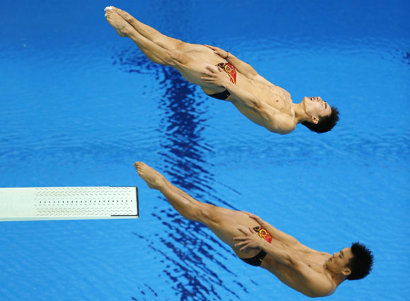 China's Luo Yutong and Qin Kai (top), who won gold, perform a dive during the men's synchronised 3m springboard final