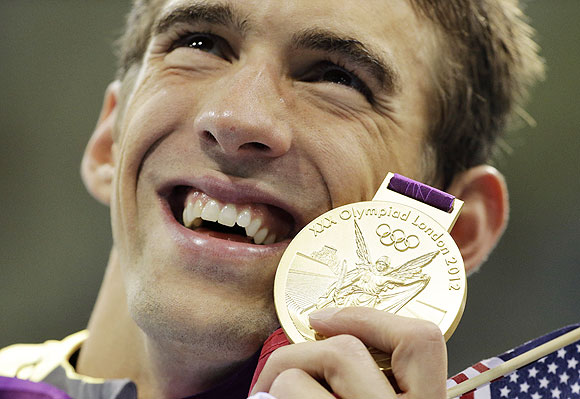 United States' Michael Phelps poses with his gold medal after the men's 4x200-meter freestyle relay swimming final at the Aquatics Centre in the Olympic Park on Tuesday