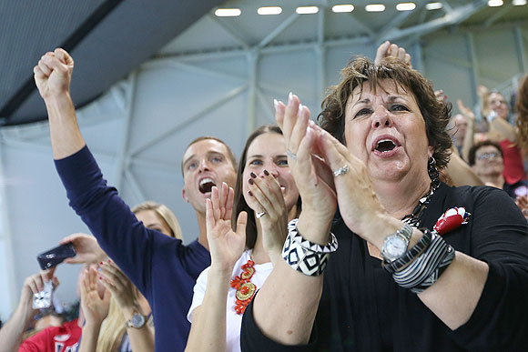 Michael Phelps's mother Debbie Phelps (right) and his sister Hilary Phelps (center) applaud as Michael Phelps of the United States receives his gold medal for the Men's 4 x 200m Freestyle relay on Tuesday