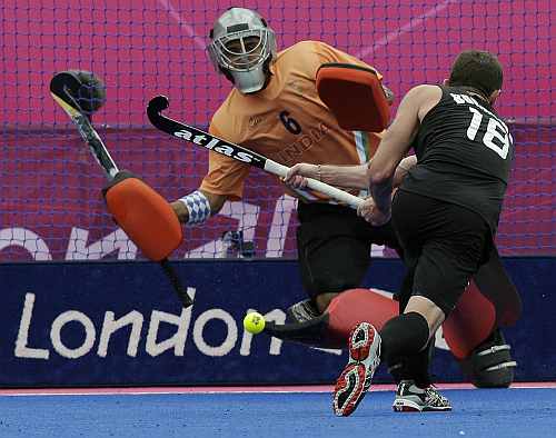 New Zealand's Phillip Burrows (18) scores a goal on a penalty as goalkeeper Bharat Kumar Chetri fails to save it during their men's hockey preliminary match