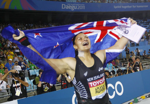 Valerie Adams of New Zealand holds her national flag after winning the women's shot put final at the IAAF World Championships in Daegu