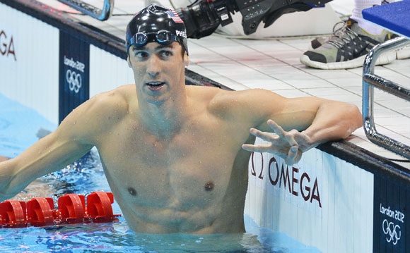 Michael Phelps of the U.S. holds up three fingers after winning the men's 200m individual medley final