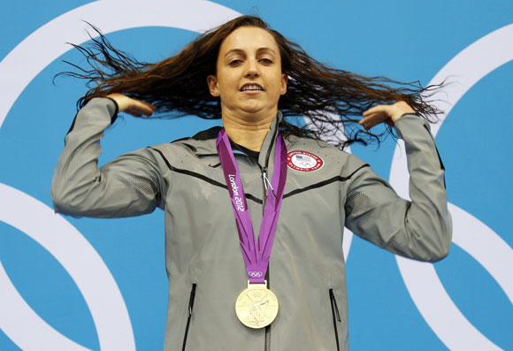 Rebecca Soni of the U.S. flips her hair as she poses with her gold medal in the women's 200m breaststroke victory ceremony