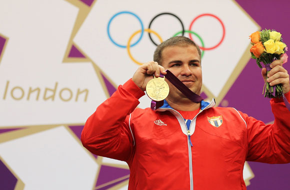 Cuba's Leuris Pupo poses with his gold medal won in the men's 25m rapid fire pistol shooting event
